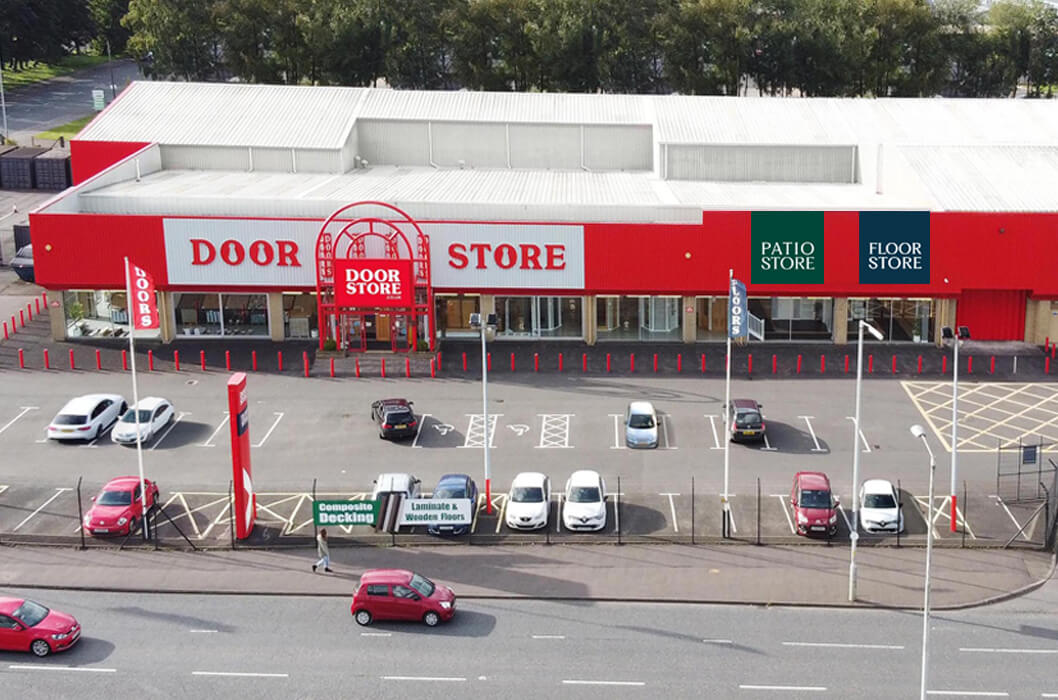 Red and white store exterior with 'Door Store' branding, surrounded by cars and a road.