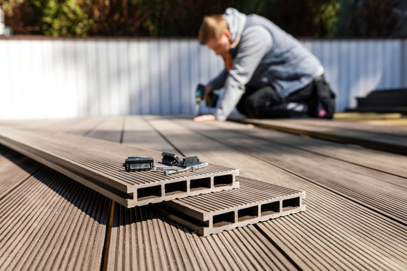 Composite decking installation with boards and fasteners in focus.