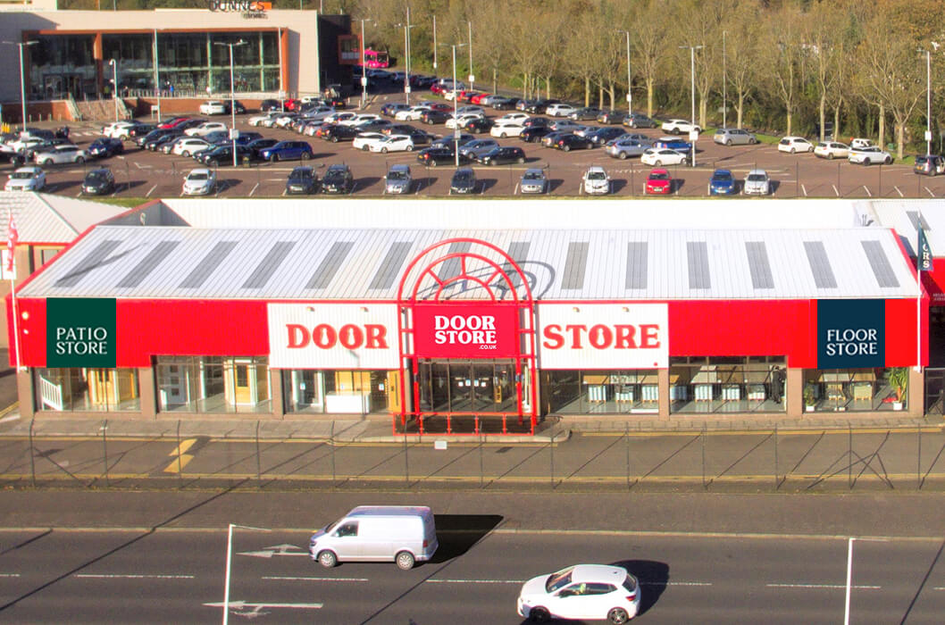 Storefront with 'Door Store' branding in a parking lot with cars and buildings in the background.